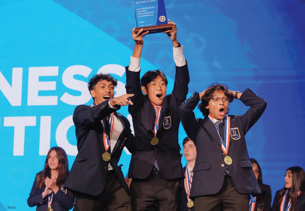 Students lifting an ICDC trophy